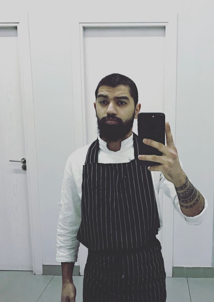 Portrait of Sergei Khatsanov in chef whites and service apron