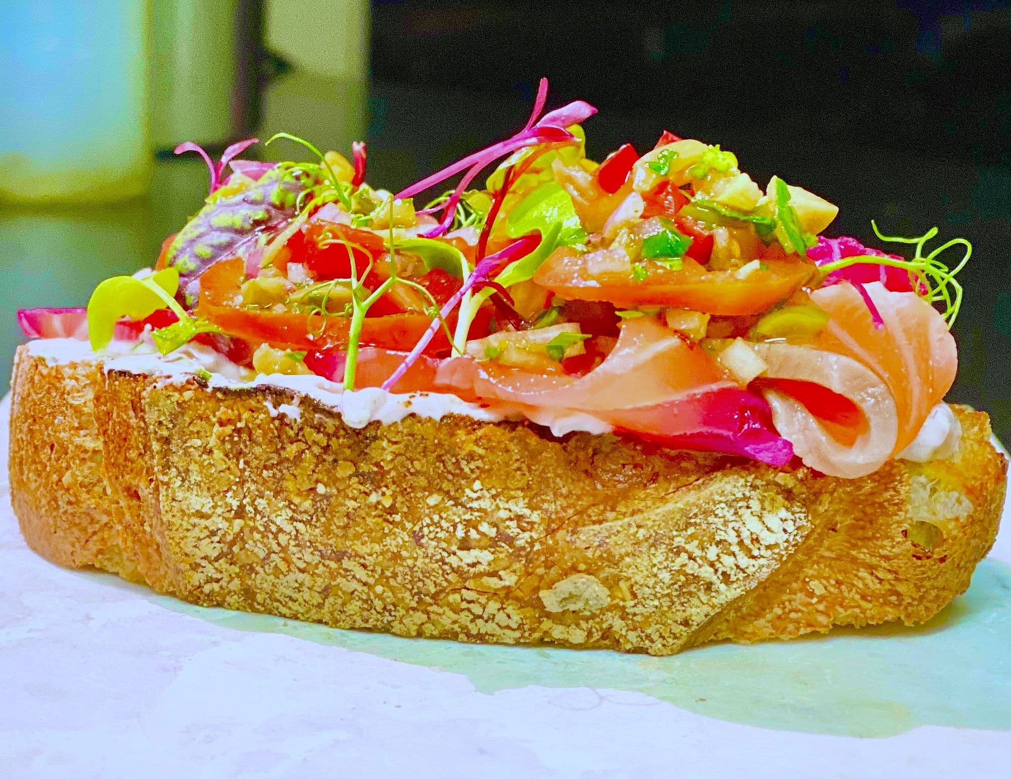 Thick sourdough slice topped with cured salmon, cream cheese, ribboned pickled vegetables and micro herbs