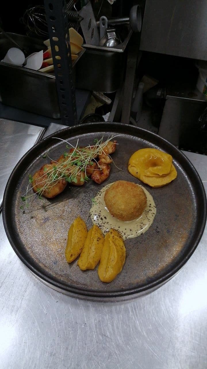 Development plate with confit apricot halves, a fried croquette and seared protein on grey stoneware