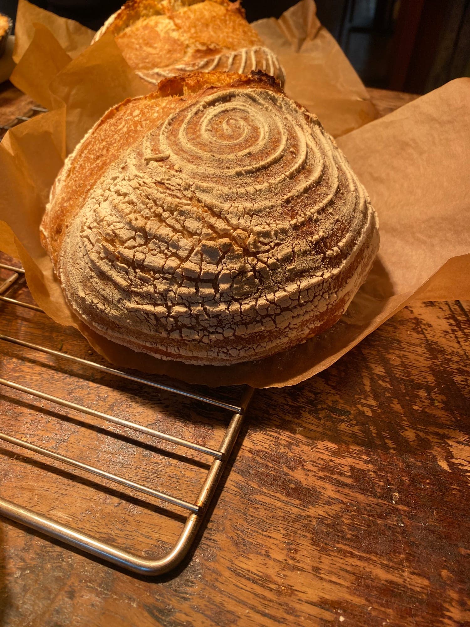 Sourdough boule with blistered crust cooling on a wire rack