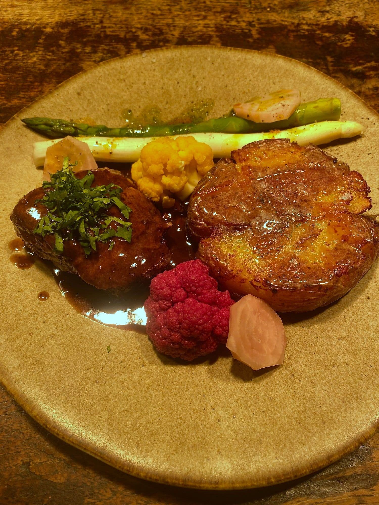 Braised beef in glossy reduction with crushed roast potato, white asparagus, purple and yellow cauliflower and pickled beetroot