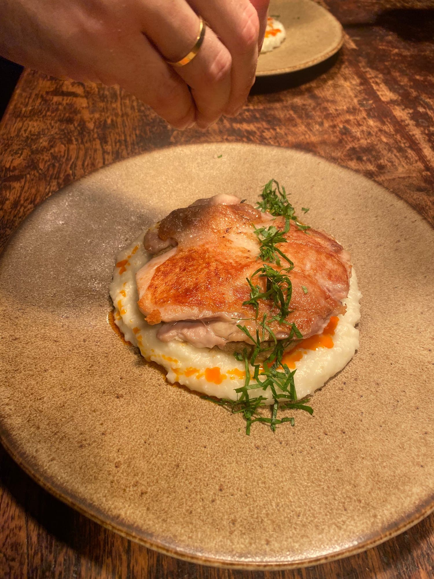 Crisp-skinned chicken thigh plated on celeriac purée