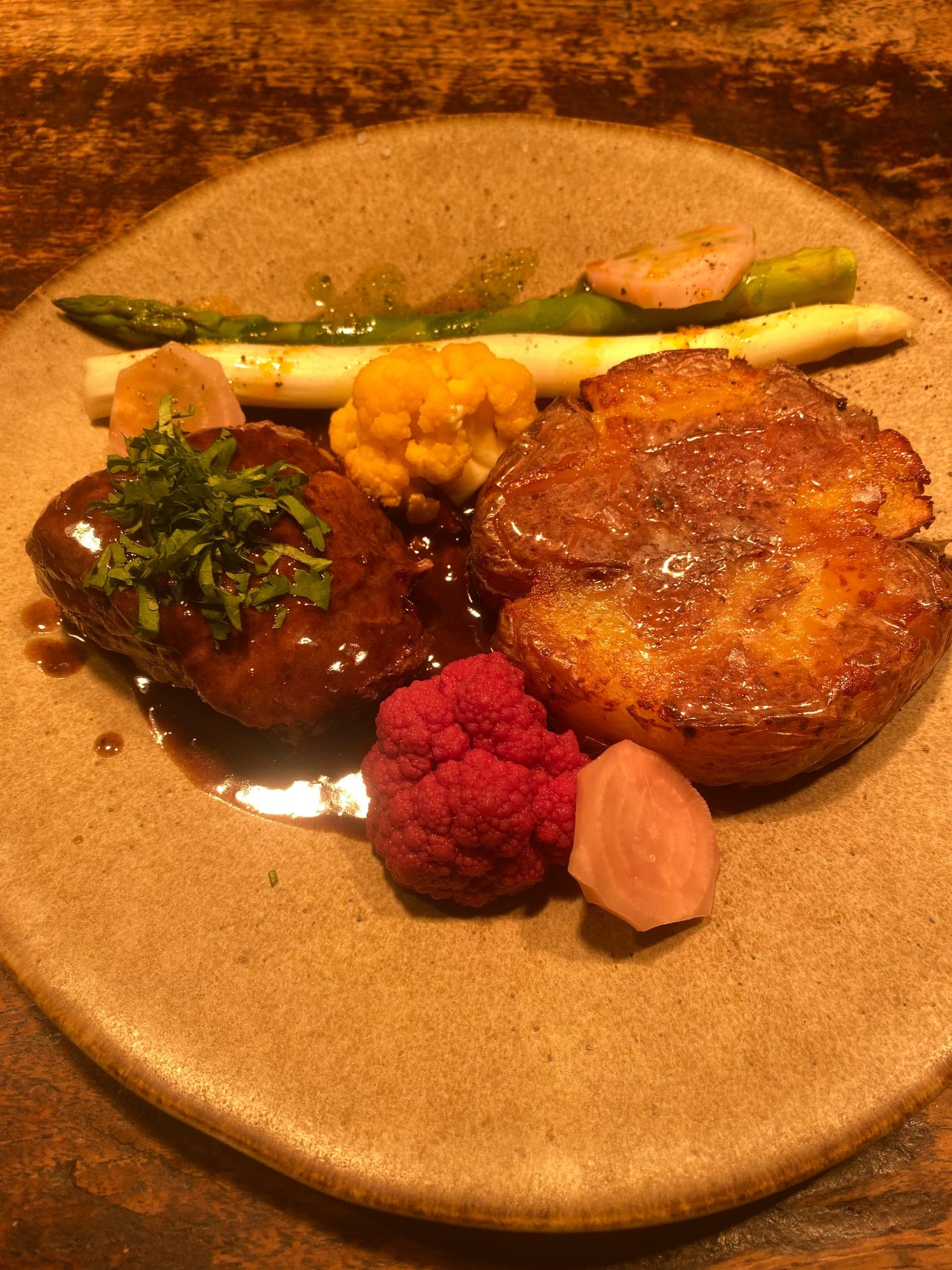 Braised beef with crushed potato and heritage cauliflower on a stoneware plate