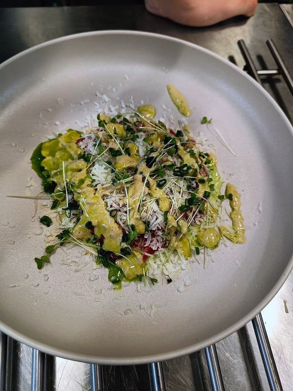 Paper-thin raw courgette slices dressed with olive oil under grated Parmesan and a pile of micro herbs