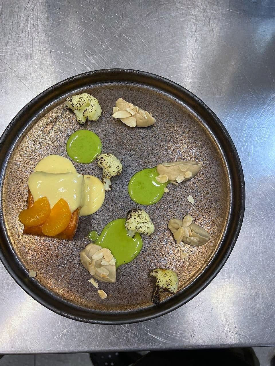 Tasting plate with dots of yellow and green purée, confit apricot, crisped cauliflower and small parcels