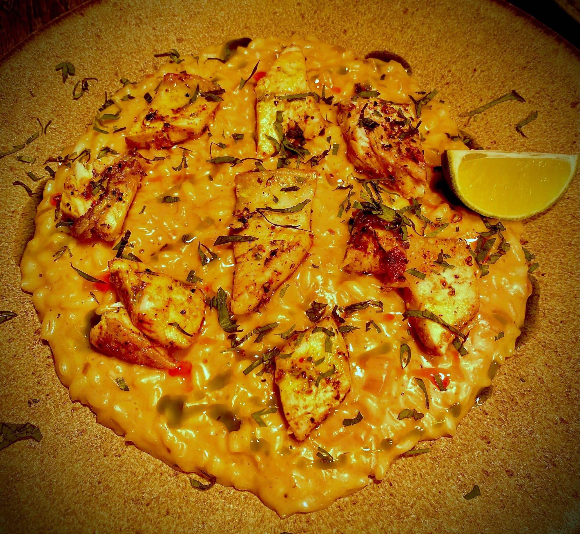 Round cheese-covered flatbread blistered from the oven, with a lemon wedge on the side