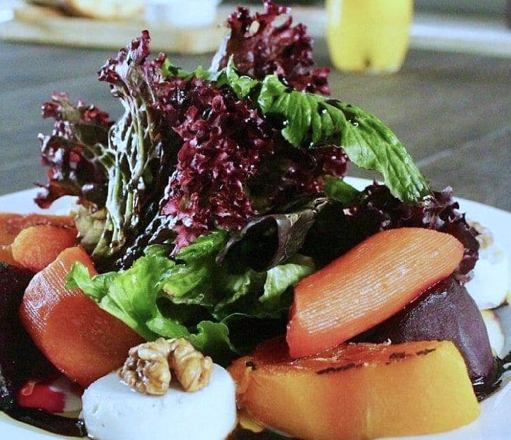 Roast beetroot and carrot with goat cheese rounds, walnuts and red and green leaves